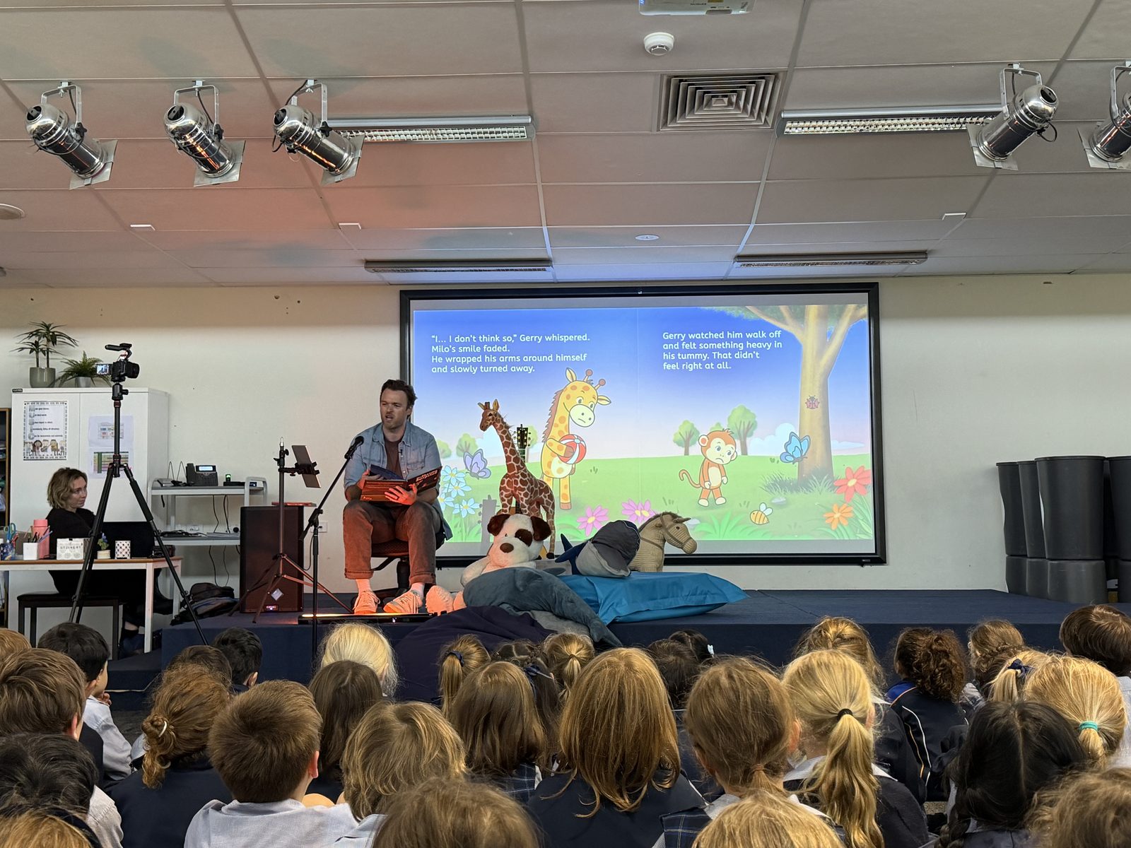Mr H reading while a picture book page is projected beside him